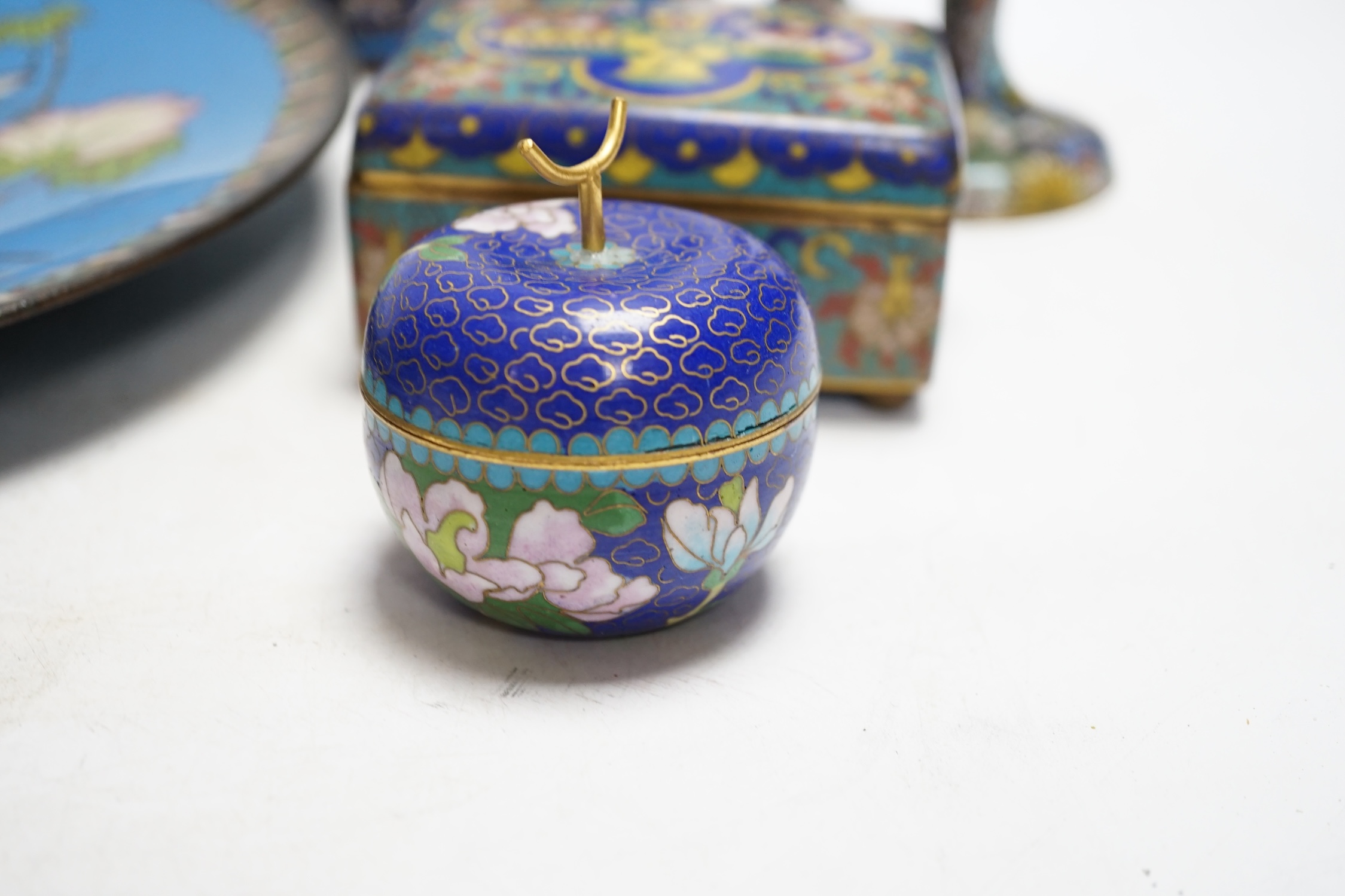 Seven Chinese or Japanese cloisonné enamel items including a pair of candlesticks, 15cm high, a charger, two boxes and a pair of vases